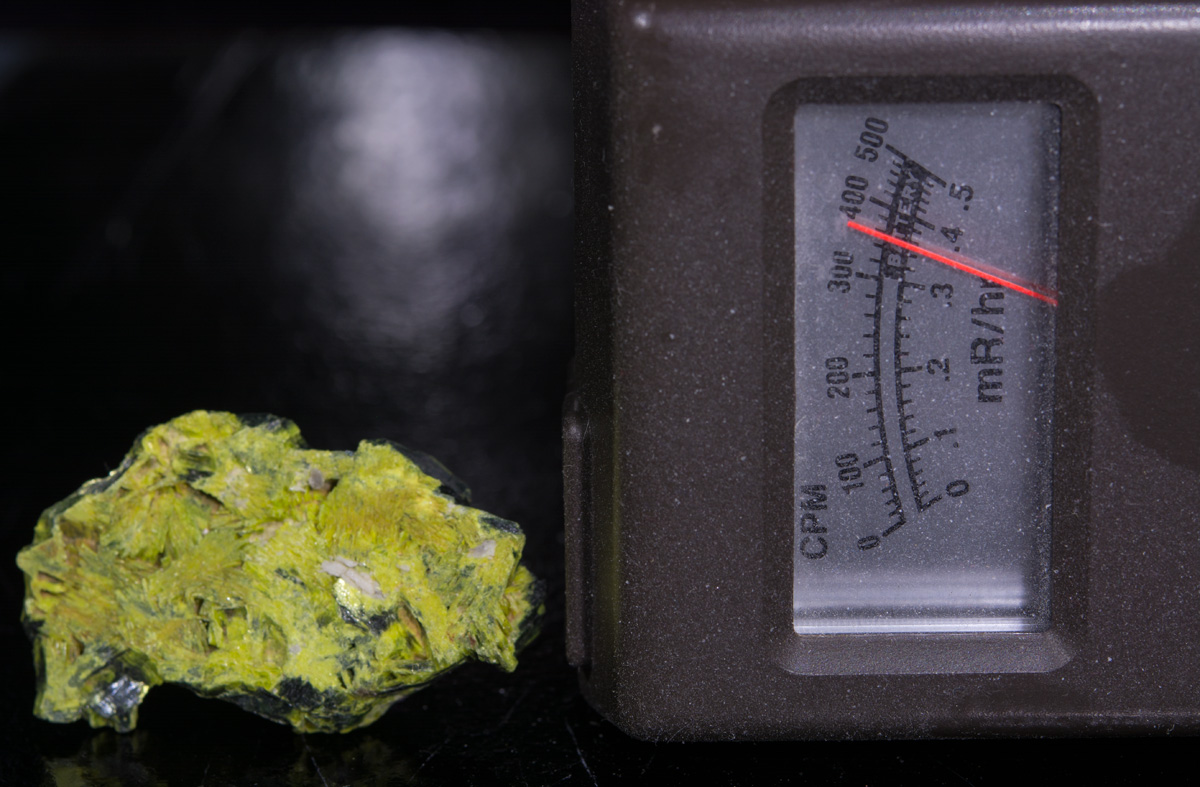 Autunite specimen with Geiger counter showing the autunite's radioactivity of 3600 CPM