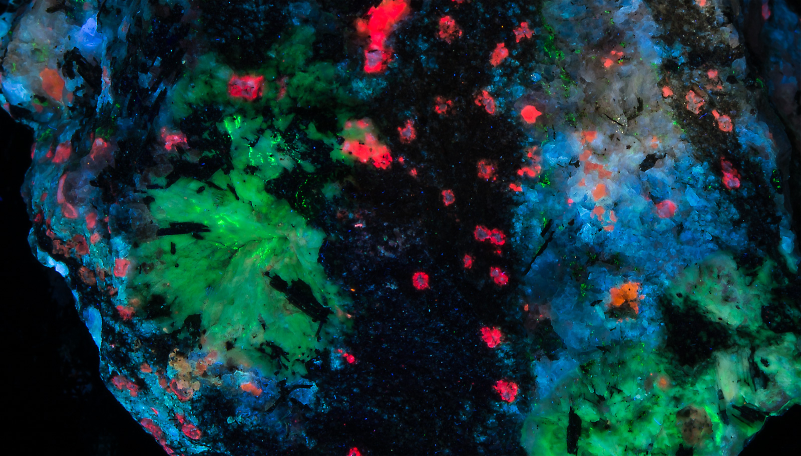 Fluorescence under shortwave UV light. Closeup of natrolite crystals.