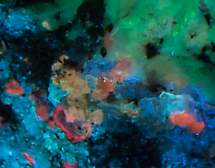 Fluorescence under shortwave UV light. Closeup of unknown mineral.