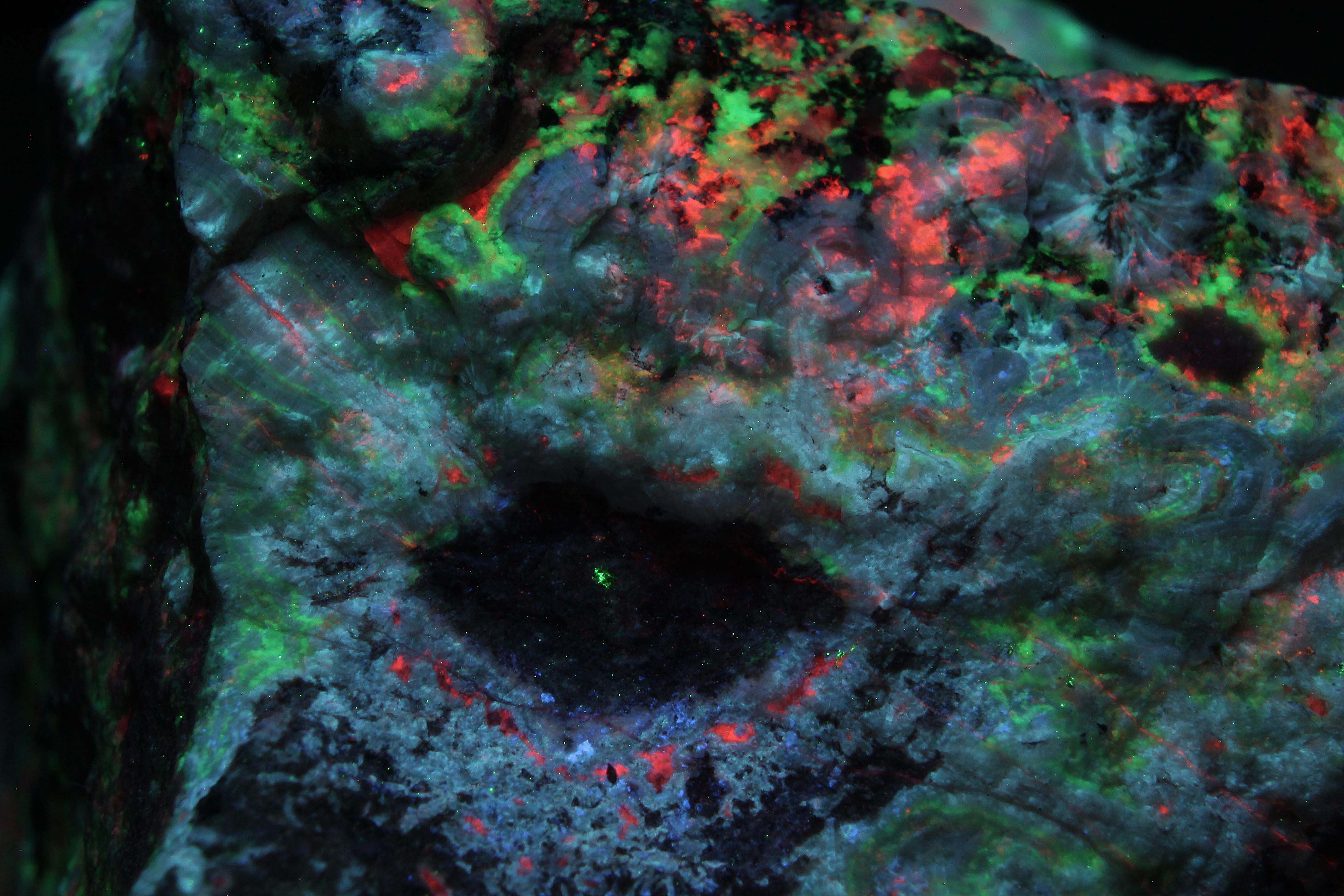Fluorescence under shortwave UV light. Eye of smithsonite and calcite